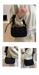 Detail of black corduroy underarm bag with silver bow embroidery and scrunchie strap