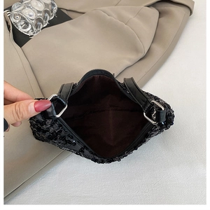 Detail view of the black sequin handbag interior showing brown lining and silver zipper