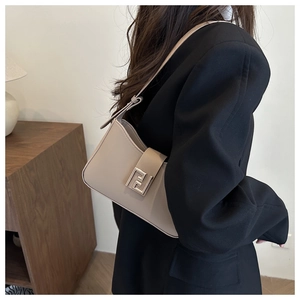 Detail der beige Achseltasche mit silberner Schnalle, präsentiert am Model im schwarzen Blazer