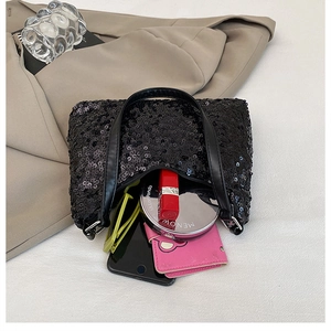 Internal capacity of the black sequin evening bag showing daily essentials and cosmetics