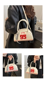 Détail du motif Los Angeles 95 sur sac Boston crème avec pompon métallique et texture cuir fin