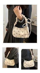 Detailed view of corduroy shoulder bag featuring black bow patterns and ruffled strap
