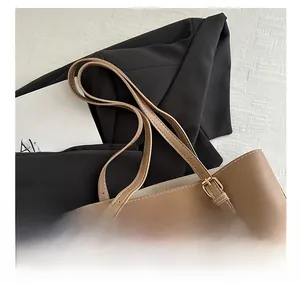 Détail du sac cabas en similicuir marron avec boucles dorées et ruban décoratif