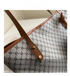 Close-up of monogram pattern canvas with brown leather trim and gold buckle detail