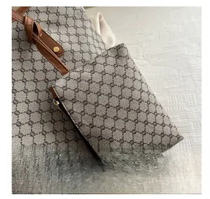 Detail of vintage pattern mini coin purse charm on tote bag with leather strap and zipper