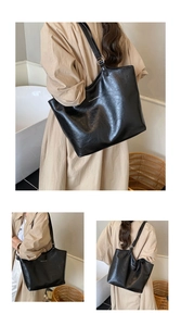 Detail of adjustable strap and crinkled black leather texture on large tote bag