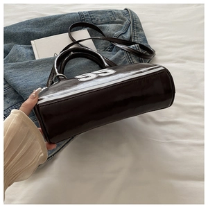 Détail du sac bowling en cuir verni marron foncé avec numéro 95 vintage et bandoulière