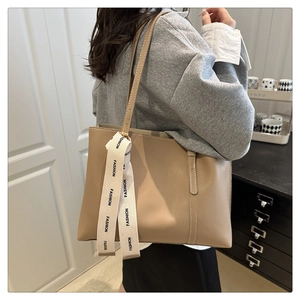 Détail d'un sac cabas beige avec longues lanières et ruban décoratif imprimé FASHION