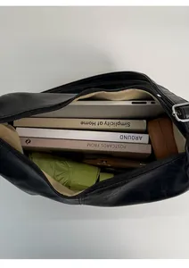 Top view of spacious black leather tote interior with light brown lining and metal zipper