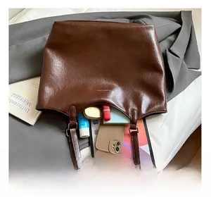 Top-down view of a dark brown vintage tote bag showing spacious internal storage for gadgets