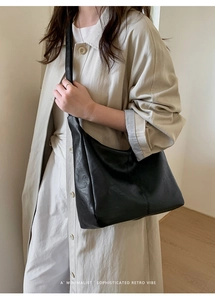 Close-up of minimalist black leather hobo bag with sophisticated retro vibe details