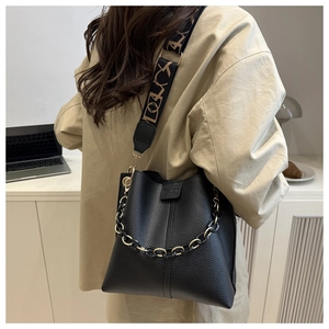Detail of black pebbled leather bucket bag with jacquard strap and gold chain strap