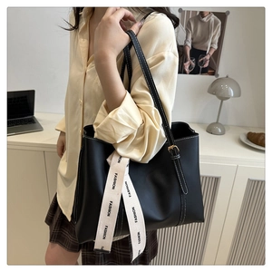 Détail du grand sac cabas noir avec coutures contrastées et pendentif en ruban Fashion