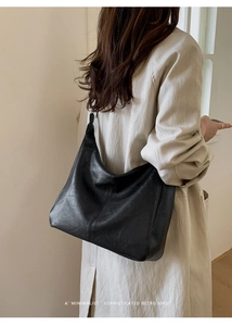 Detail of minimalist black PU hobo bag featuring vertical stitching and a retro vibe