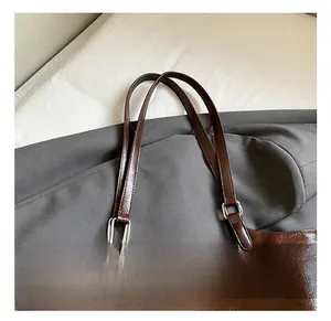 Detailed view of dark brown oil wax leather handle and silver square metal hardware
