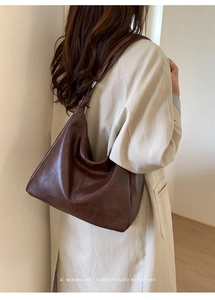 Minimalist retro dark brown leather hobo bag side view on model with soft draping detail