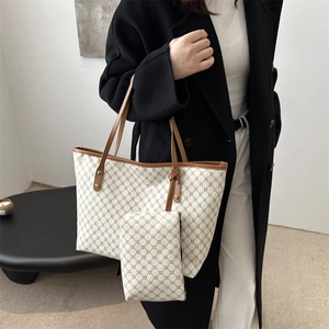 Detail of minimalist tote bag set with brown monogram pattern and leather straps
