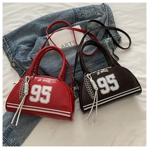 Détail de sacs fourre-tout en cuir brillant rouge et marron avec nœuds de chaîne en argent