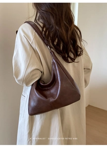 Detail of dark brown hobo bag with vintage leather texture and wide shoulder strap