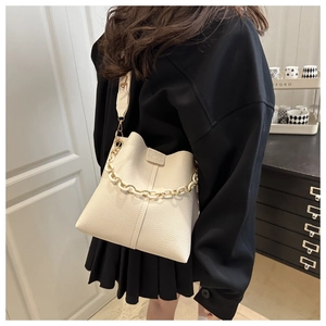 Detail of off-white lychee pattern bucket bag with gold chain and wide strap