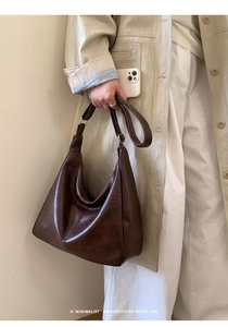Deep brown retro hobo bag shown on a model with a beige trench coat for size visualization