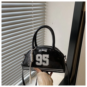 Detail of black faux leather crescent bag with Los Angeles 95 print and silver chain tassel