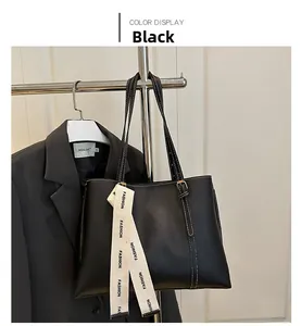 Détail du cabas en cuir noir avec coutures contrastées blanches et sangle de mode chic