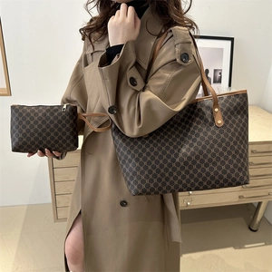 Detailed view of dark brown tote bag set with vintage pattern on model in trench coat