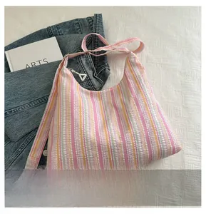 Détail d'un sac cabas en toile rayée colorée avec tissu texturé et large bandoulière