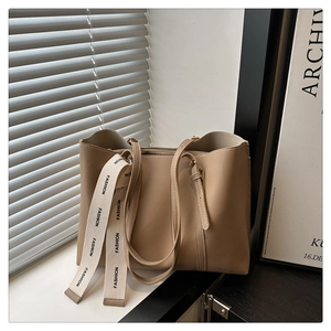 Vue détaillée du sac cabas en similicuir beige avec ruban mode et bandoulière réglable