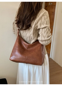 Close-up of brown vintage tote bag with vertical stitching on textured synthetic leather