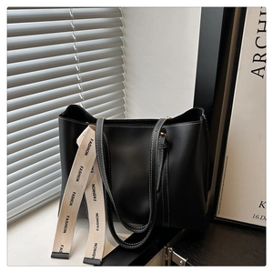 Détail du cabas noir avec surpiqûres contrastées blanches et bandoulière en toile