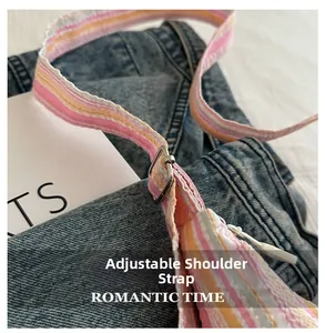 Détail d'une bandoulière en toile rayée ajustable avec une boucle en métal argenté brillant