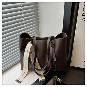 Détail du cabas marron foncé avec surpiqûres blanches et sangle tissée Fashion