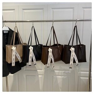 Détail de quatre sacs fourre-tout colorés avec sangles fashion sur un support