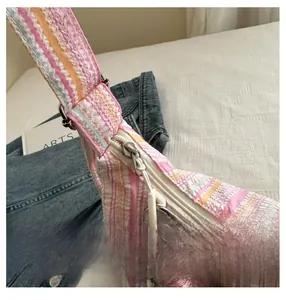 Détail du sac cabas rayé rose et blanc montrant la fermeture éclair fluide et l'anse