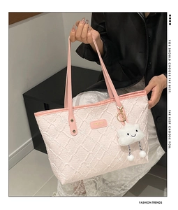 Detail of pink tote bag with textured embossed grid pattern and cloud charm