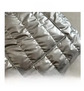 Détail macro du tissu matelassé argenté métallisé avec texture de surpiqûres carrées