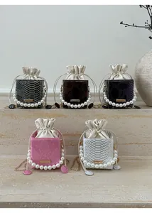 Detail of five faux-snakeskin mini square bags with pearl handles and chain straps