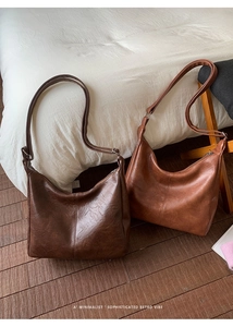 Detail of vintage PU leather tote bags in dark brown and caramel with soft texture