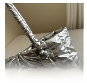 Détail du sac cabas matelassé argent métallique avec œillets dorés et bandoulière nouée
