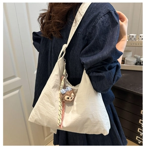 Détail du grand sac porté épaule blanc en forme de lune avec petit ours en peluche