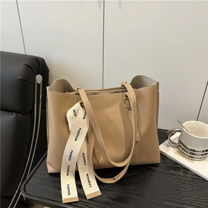 Sac fourre-tout beige vintage en cuir souple avec ruban FASHION sur table bois