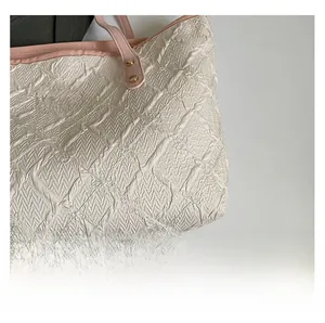 Detail showing the quilted texture and pink leather handle of the large tote bag