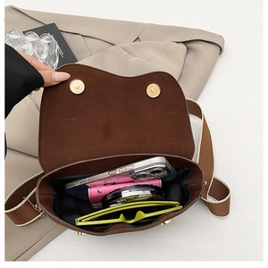 Vue intérieure d'un sac besace marron montrant sa capacité pour les objets du quotidien
