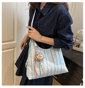 Détail du sac cabas en toile rayée avec pendentif ours en peluche et grande taille