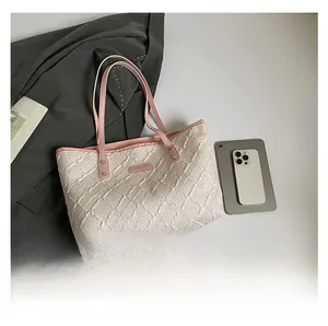 Top view of cream quilted tote bag with pink leather handles and commute accessories