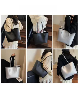 Detail view showing large tote bag with embossed lettering in black and silver finishes
