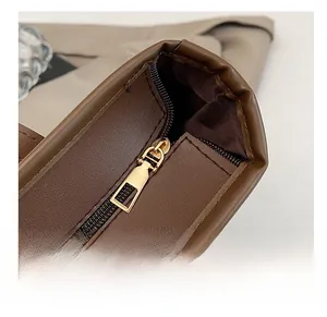 Gros plan sur la fermeture éclair dorée et la couture de ce sac cabas marron