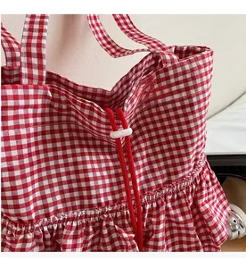 Detail of red and white checkered tote bag with drawstring closure and ruffled trim